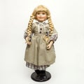 Vintage doll with a beautiful dress and golden braids on the white background