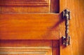 The vintage door handle on an old wooden door background and lighting and shadow in the morning.