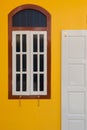 A vintage door and window on yellow wall Royalty Free Stock Photo