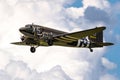 Vintage Douglas C-47 Dakota military transport plane in US Army Air Force livery in flight during D-Day 75 memorial flights over