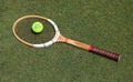 Vintage Dunlop tennis racket and Slazenger Wimbledon Tennis Ball on the grass tennis court.