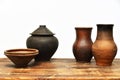Vintage earthenware clay pots, bowls and jugs on a wooden table on a white background Royalty Free Stock Photo
