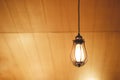 Vintage Edison light bulb hanging over against wooden background Royalty Free Stock Photo