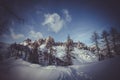 Vintage effect of snowy path with larch trees and backdrop of dolomite peaks