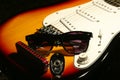 Vintage electric guitar, harmonica, sunglasses on black background