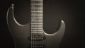 A vintage electric guitar standing upright with textured noir concept as black silver wallpaper. Royalty Free Stock Photo