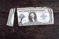 Vintage embroidery scissors cutting old paper dollar bill Royalty Free Stock Photo