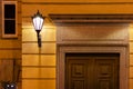 Vintage entrance door with a lantern. historic building facade. stone aged