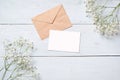 Vintage envelope with flowers on light blue wooden background. Banner mockup for womans or mother day, wedding invintation, easter