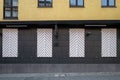 Vintage exterior of building with old rough brick wall facade and big closed wooden white shutter windows. Royalty Free Stock Photo