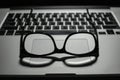 Vintage eye glasses on laptop trackpad low key light