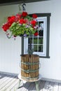 Vintage facade with window, decorated by an old fruit and grape crusher in cast iron and wood and a vase of hanging flowers Royalty Free Stock Photo