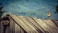 Vintage faded image of an old wooden barn roof falling apart dew to lack of maintenance, a mountain farm