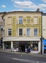 Vintage faded yellow signs for AA, tractors etc on building wall in Bath Street, Frome, UK