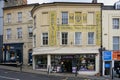 Vintage faded yellow signs for AA, tractors etc on building wall in Bath Street, Frome, UK