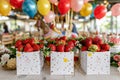 Vintage fair ripe strawberries in boxes with balloons and carousel for summer fun Royalty Free Stock Photo