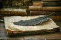 Vintage Feather Quill on Aged Paper with Old Books in Antique Setting Royalty Free Stock Photo