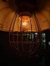 Vintage Filament lamp hanging in a mysterious cafÃÂ©. The light is shining dim.