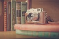 Vintage film camera with a leather case on stack of books Royalty Free Stock Photo