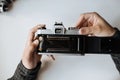 Vintage film camera. Men`s hands recharge 35mm film Royalty Free Stock Photo