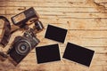 Vintage film camera and two blank photo frames on wooden table. Top view with copy space Royalty Free Stock Photo