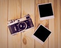 Vintage film camera and two blank photo frames on wooden table. Royalty Free Stock Photo