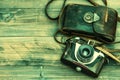 Vintage film photo camera with leather bag on wooden background Royalty Free Stock Photo