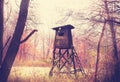 Vintage filtered photo of hunting pulpit in forest.
