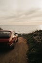 Vintage-filtered photo from up high on the right side of a 1990s classic red sports car with beautiful view of sunset by the sea Royalty Free Stock Photo