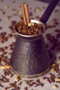 Vintage filtered turkish coffee pot filled with coffee beans on canvas background Royalty Free Stock Photo
