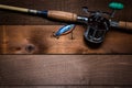 A vintage fishing rod and reel on a wooden plank background Royalty Free Stock Photo