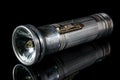 Vintage flashlight in aluminium case with a broken light bulb on black background Royalty Free Stock Photo