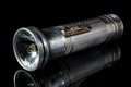 Vintage flashlight in aluminium case with a broken light bulb on black background