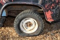 Vintage flat tire on retro truck parked on wood chips