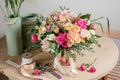 Vintage floristic background, colorful roses, antique scissors and a rope on an old wooden table