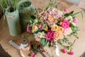 Vintage floristic background, colorful roses, antique scissors and a rope on an old wooden table Royalty Free Stock Photo