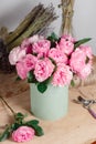 Vintage floristic background, colorful roses, antique scissors and a rope on an old wooden table