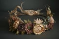 a vintage flower crown with a mix of dried and fresh blooms, tied together with delicate ribbons.