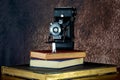 Vintage Folding Film Camera and Old Books on a Wooden Shelf Royalty Free Stock Photo