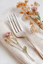 Vintage fork elegantly resting on a soft linen napkin adorned with delicate dried flowers, creating a charming and Royalty Free Stock Photo