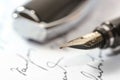 Vintage fountain pen with golden feather and cap on a handwritten paper, macro shot with selected focus Royalty Free Stock Photo