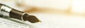 Vintage fountain pen with golden quill lies on blurry papers Royalty Free Stock Photo