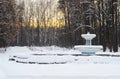 Vintage fountain in public park at winter time. Snow on trees. Royalty Free Stock Photo