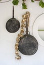 Vintage frying pan and bunch of garlic on a white wall, closeup. Kos island, Greece