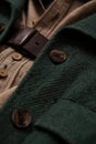 Vintage garment detail, green wool coat with leather belt.- AI Generated