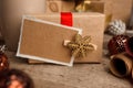 Vintage gift box package with blank gift tag on old wooden background, xmas decorative elements. Christmas festive close up Royalty Free Stock Photo
