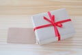 Vintage gift box with red ribbon bow and card on wood background Royalty Free Stock Photo