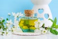 Vintage glass bottle with cosmetic oil massage oil, tincture, infusion, extract and white flowers close up. Aromatherapy, spa Royalty Free Stock Photo