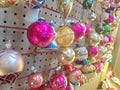 Vintage Glass Christmas Ornaments in an Antique Mall, hanging from a Pegboard. Silver, gold, pink spheres for decorating the tree. Royalty Free Stock Photo