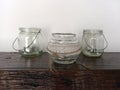 Vintage glass jars used as candle holders on rustic wooden table. Hanging clear glass candle holder. Retro decor. Home and